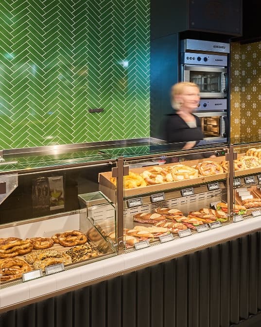 Brezeln und Backwaren in der gläsernen Verkaufsauslage des Brezelkönig Shop & Café bei The Yards.
