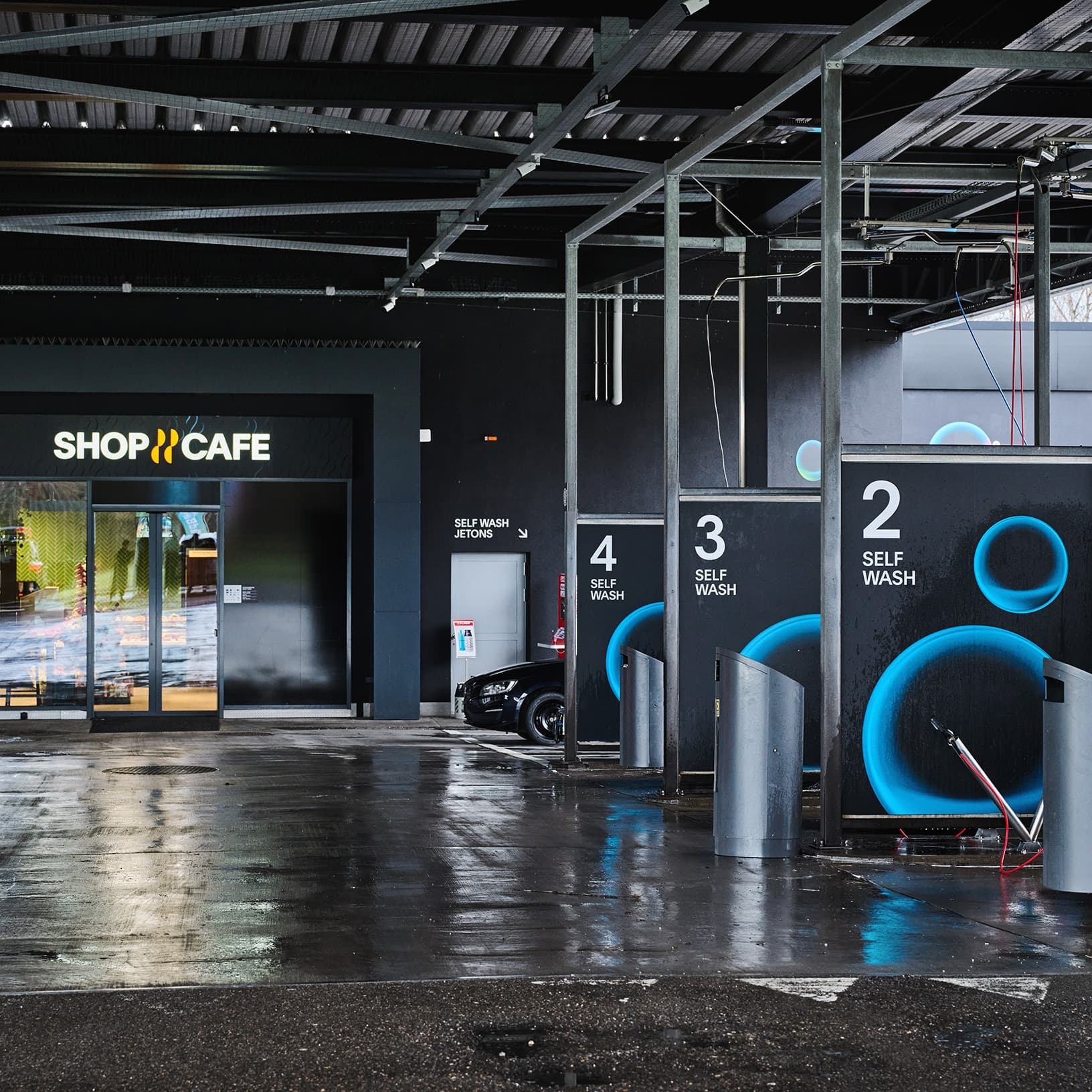 Überdachte Self-Wash-Waschplätze neben dem Shop & Café der SOCAR Tankstelle bei The Yards in Rümlang.