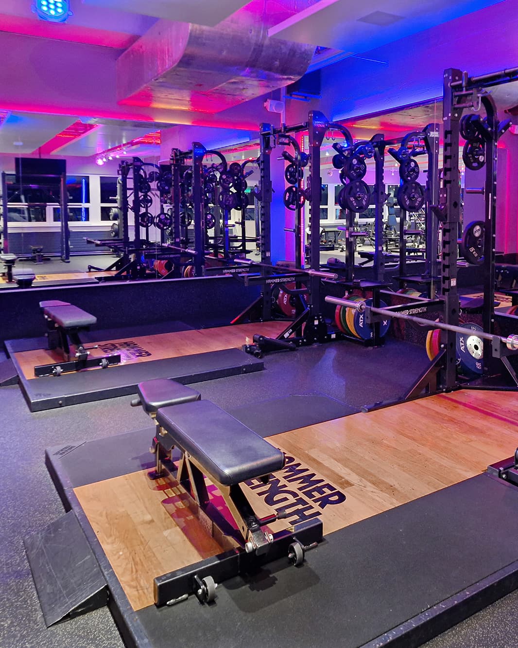 Krafttrainingsbereich mit Langhantelstationen und Hantelbänken im clever fit bei The Yards.
