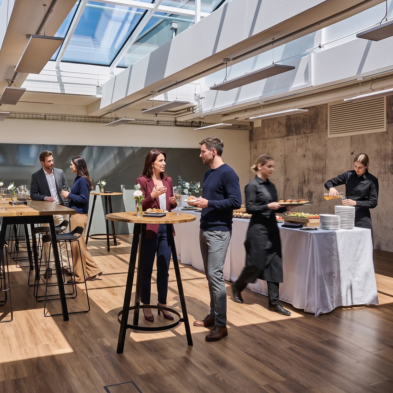 Gäste im Gespräch an Stehtischen mit Fingerfood und Cateringservice bei The Yards Events.