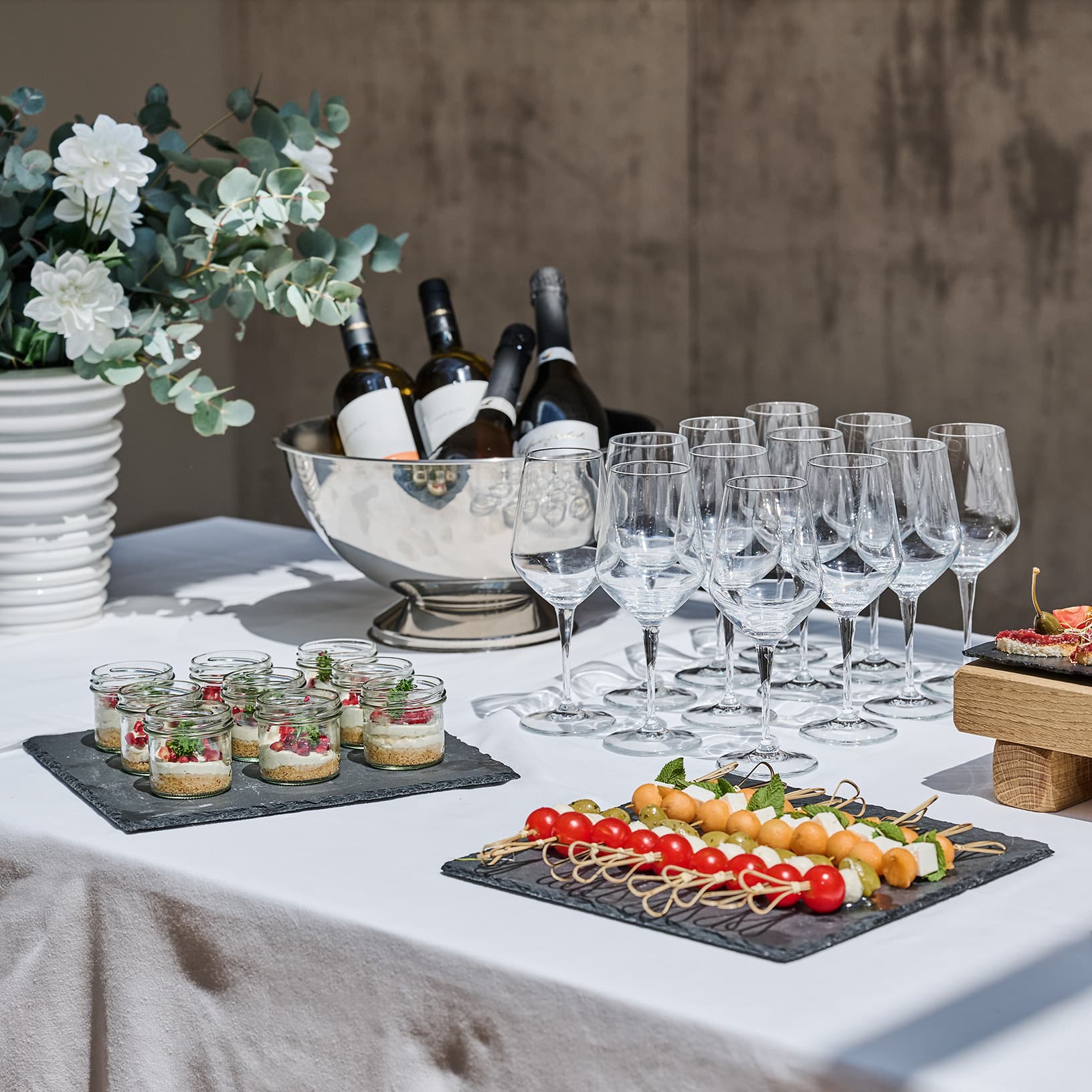 Apérobuffet mit Fingerfood, Weingläsern und Blumendekoration bei The Yards Events.