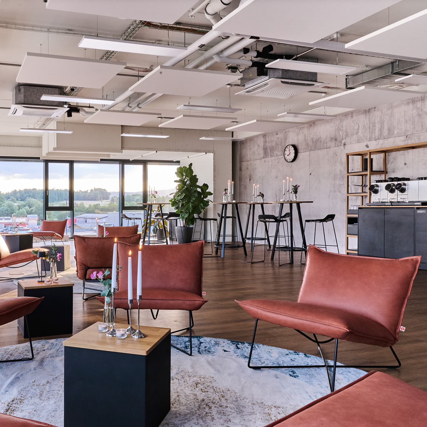 Lounge mit Sesseln, Stehtischen und einer Kaffeemaschine bei The Yards Events.
