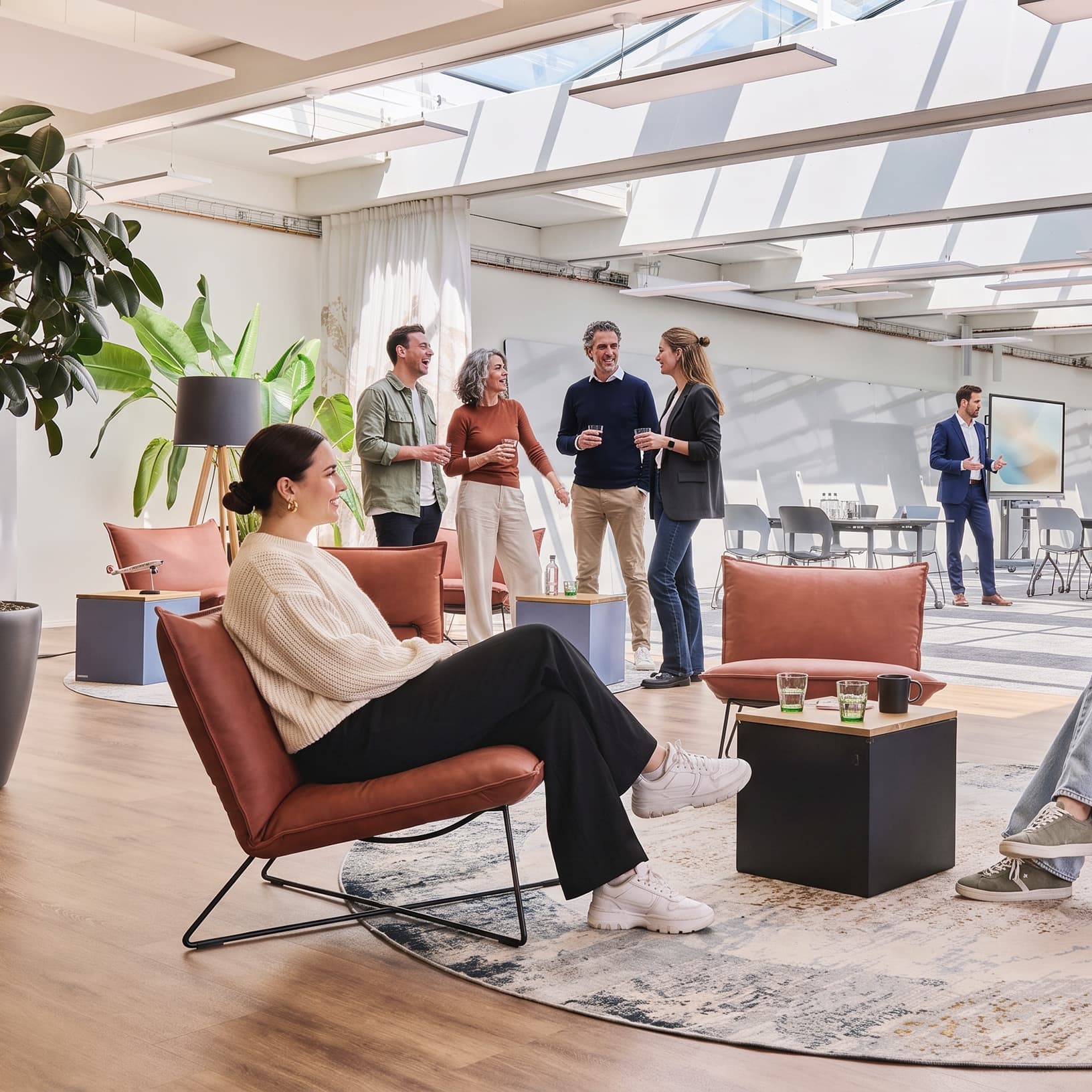 Gäste unterhalten sich in einer Lounge mit Sesseln und Beistelltischen bei The Yards Events.