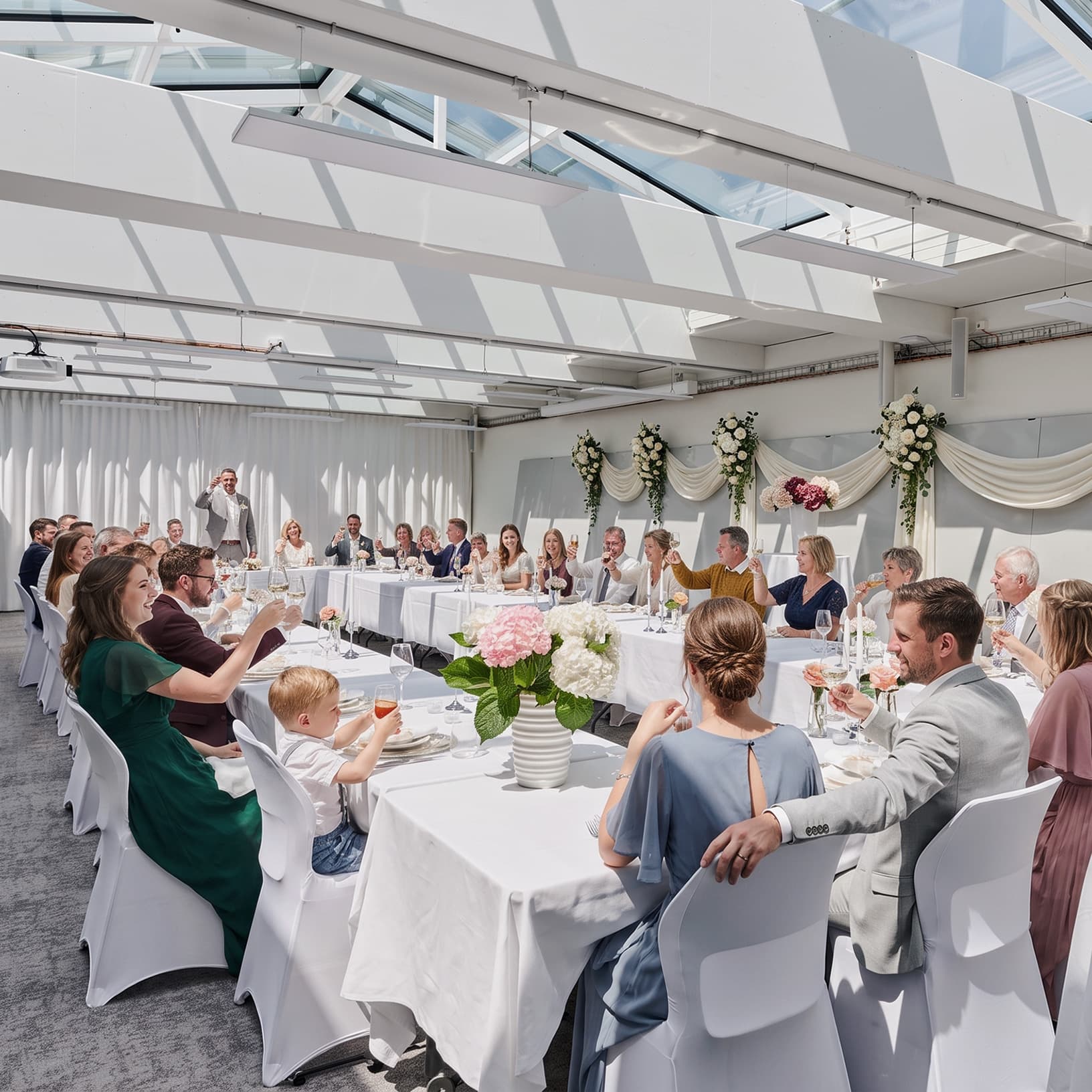 Gäste stossen an festlich gedeckten Tafeln bei einer privaten Feier in The Yards Events an.