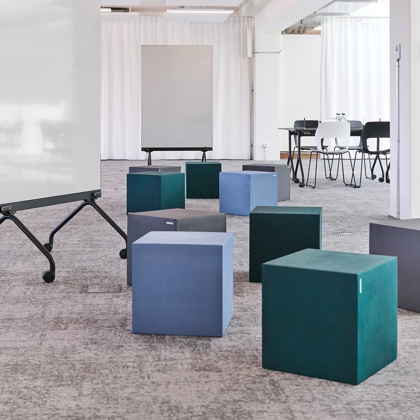 Informelles Workshopsetting mit farbigen Sitzwürfeln und mobilem Whiteboard bei The Yards Events.