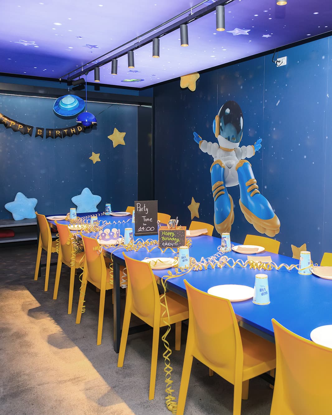 Für einen Kindergeburtstag gedeckter Tisch mit Weltraumdekoration im Partyraum des Flip Lab bei The Yards.