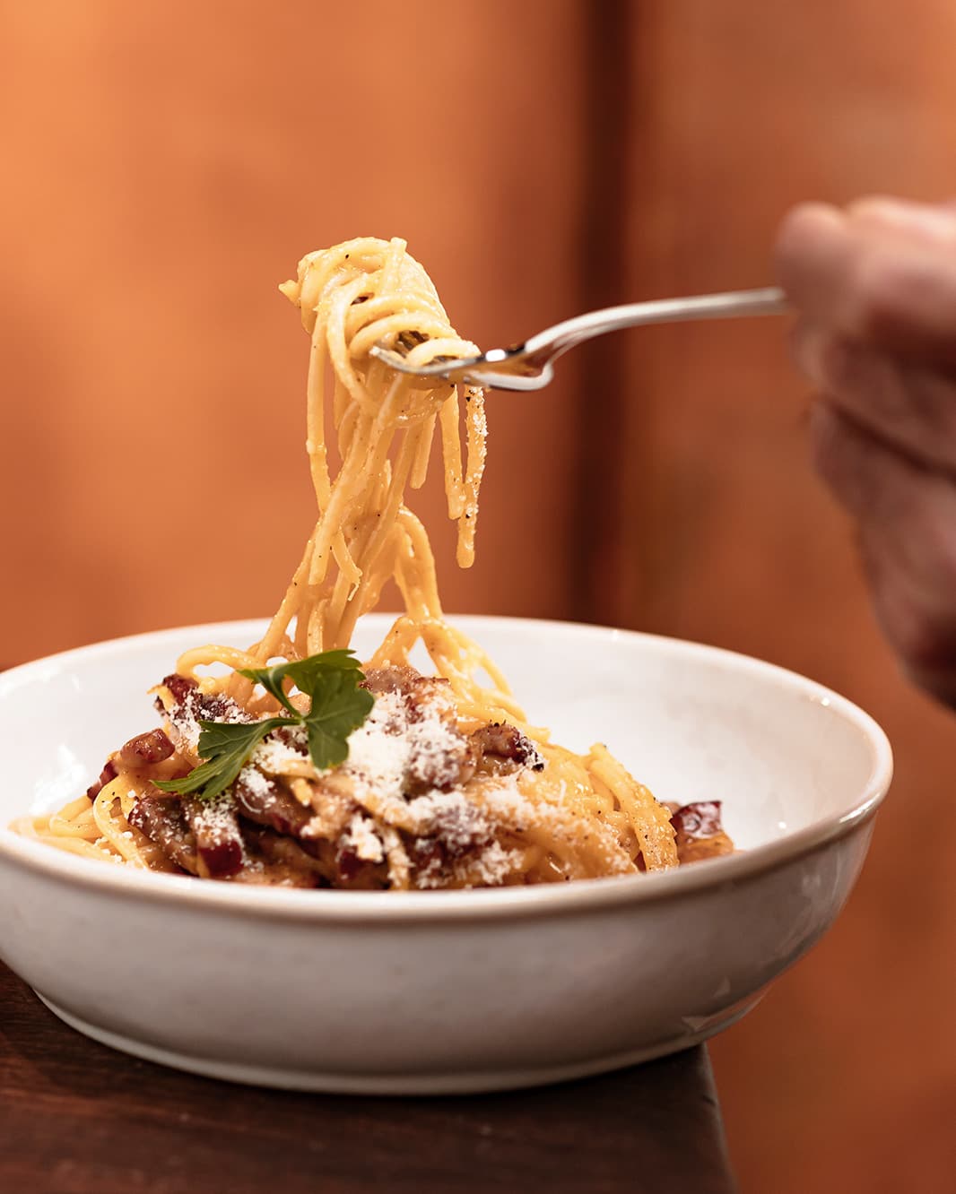 Spaghetti mit cremiger Sauce und geriebenem Käse werden mit einer Gabel aus einer Schüssel im Ristorante Piazza Meraviglia bei The Yards in Rümlang gehoben.